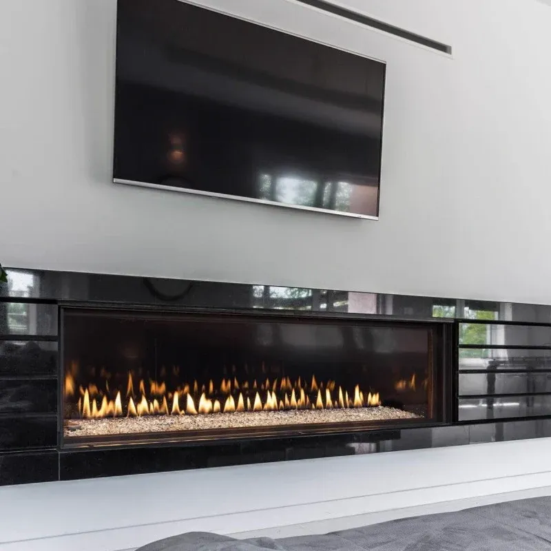 Chimenea de gas lineal empotrada bajo un televisor en un salón