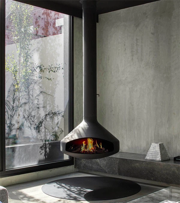 Chimenea colgante Andorra junto a una pared de hormigón y un ventanal con plantas